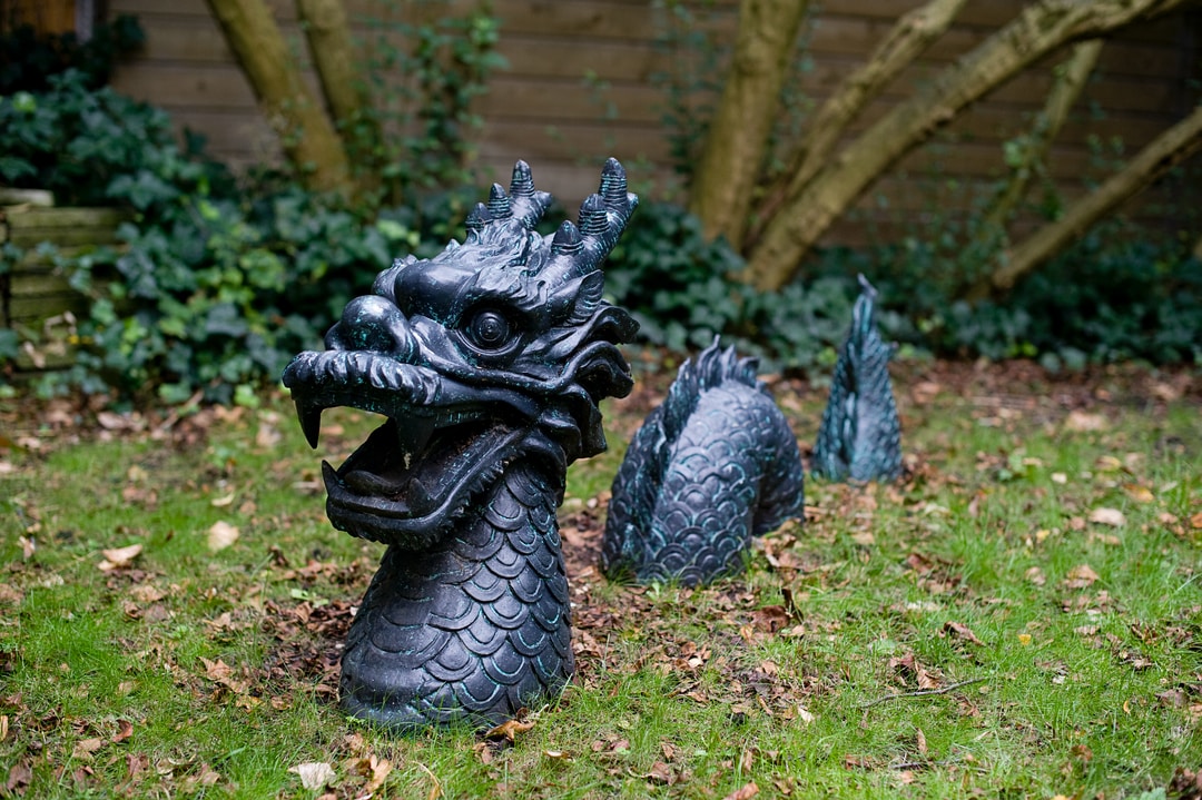 black dragon statue on green grass field